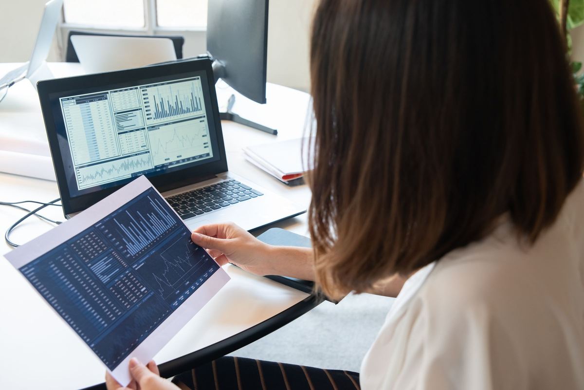 Analyst reviewing performance charts on a laptop and tablet