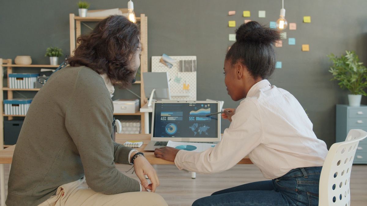 Two colleagues reviewing analytics on a laptop