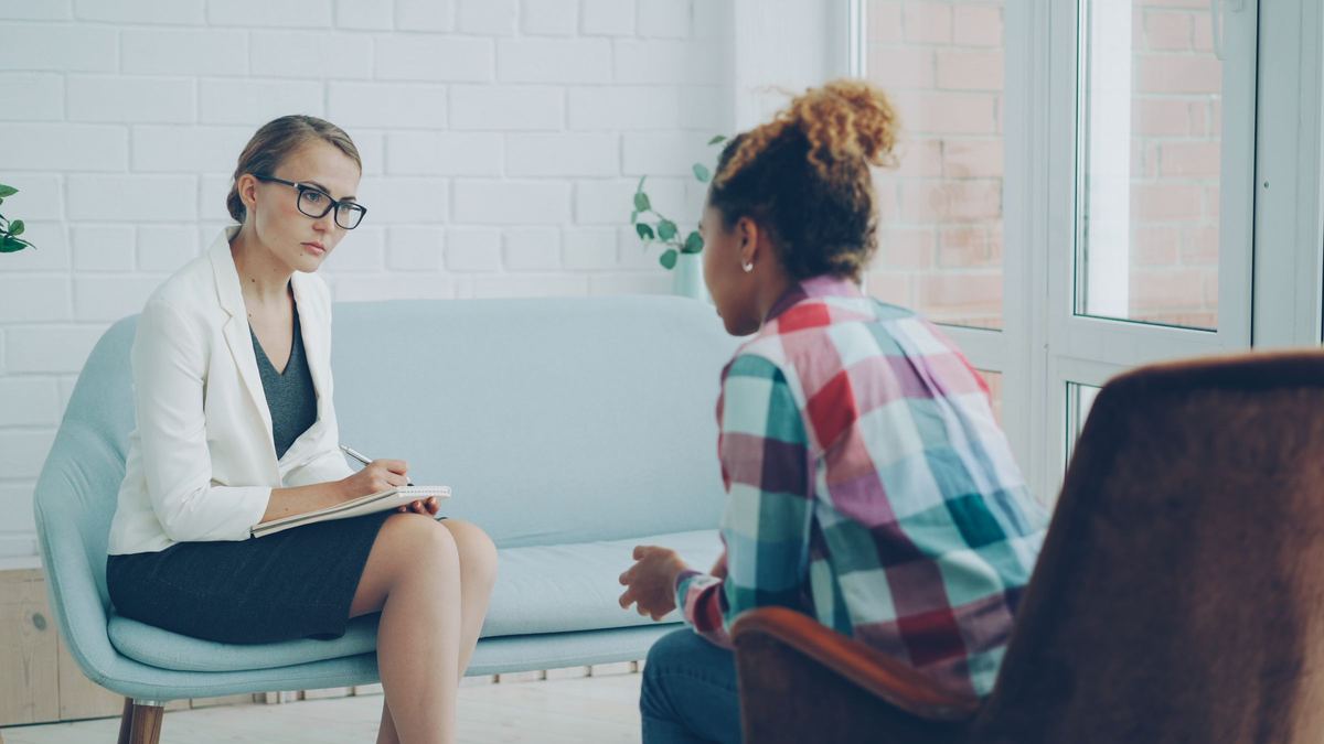 Counselor listening to a client in a calm therapy office