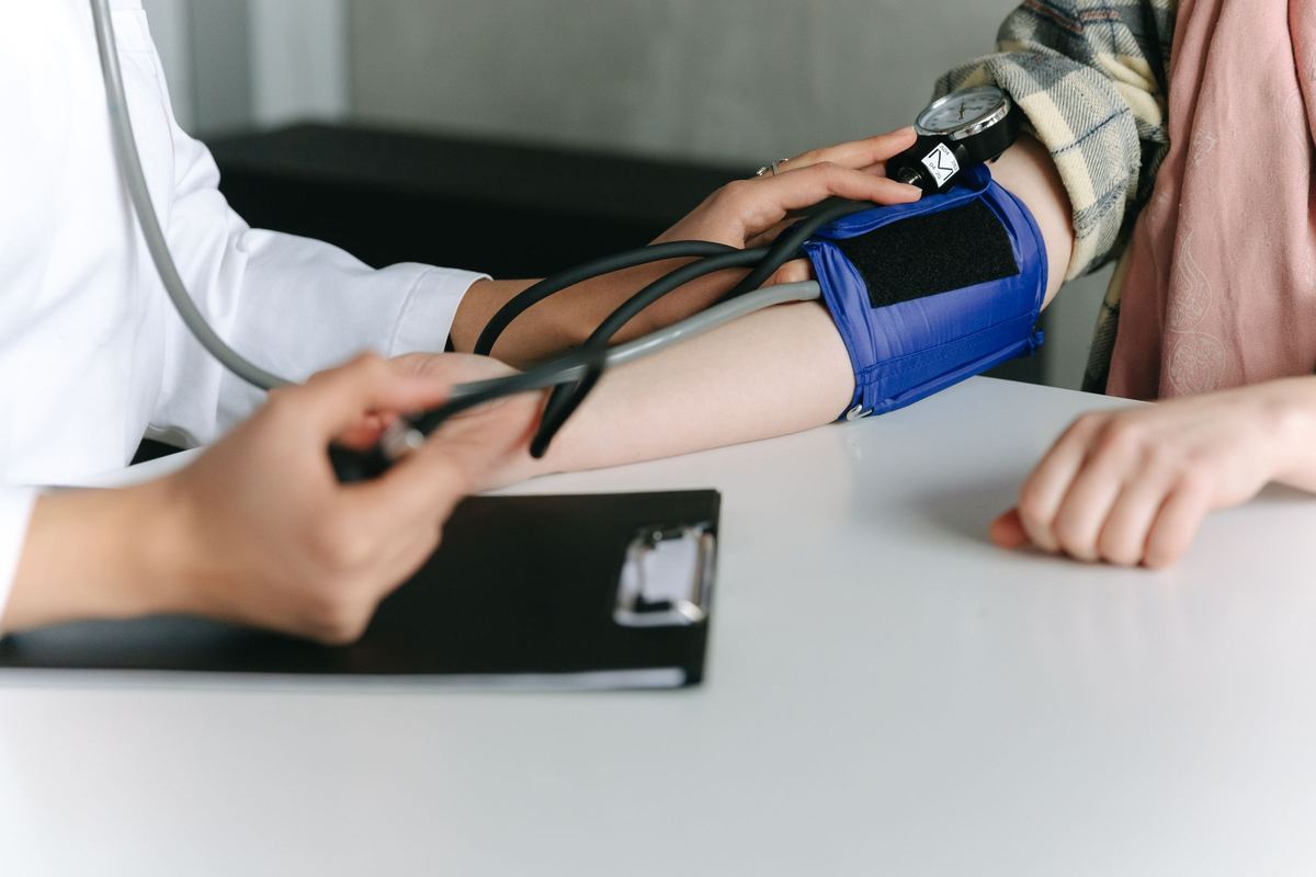 Clinician measuring a patient's blood pressure during a heart health visit