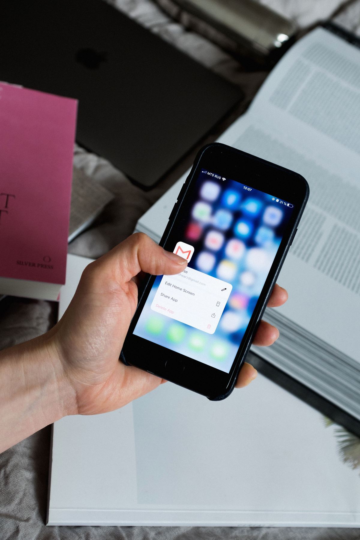 Hand holding a smartphone with an email app open