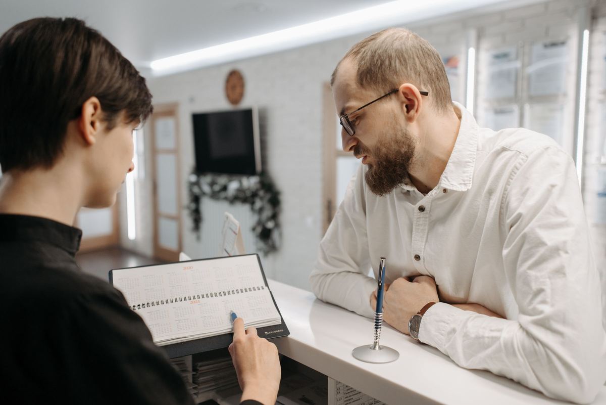 Front desk team member scheduling a patient appointment at a dental clinic