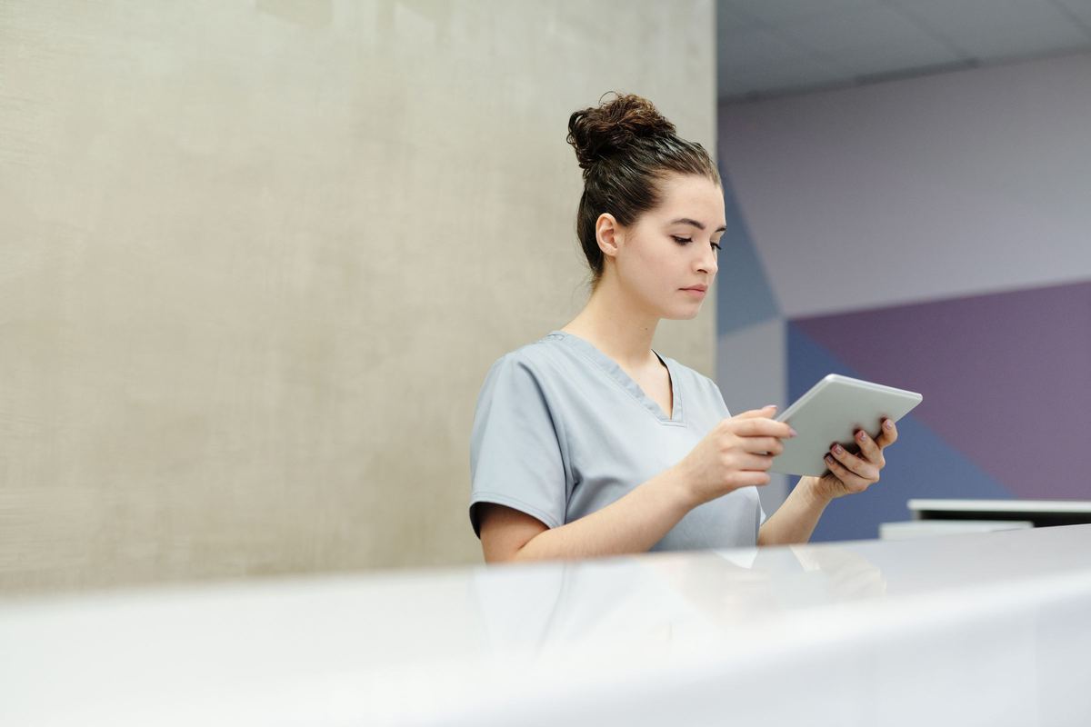 Medical receptionist managing appointment requests on a tablet