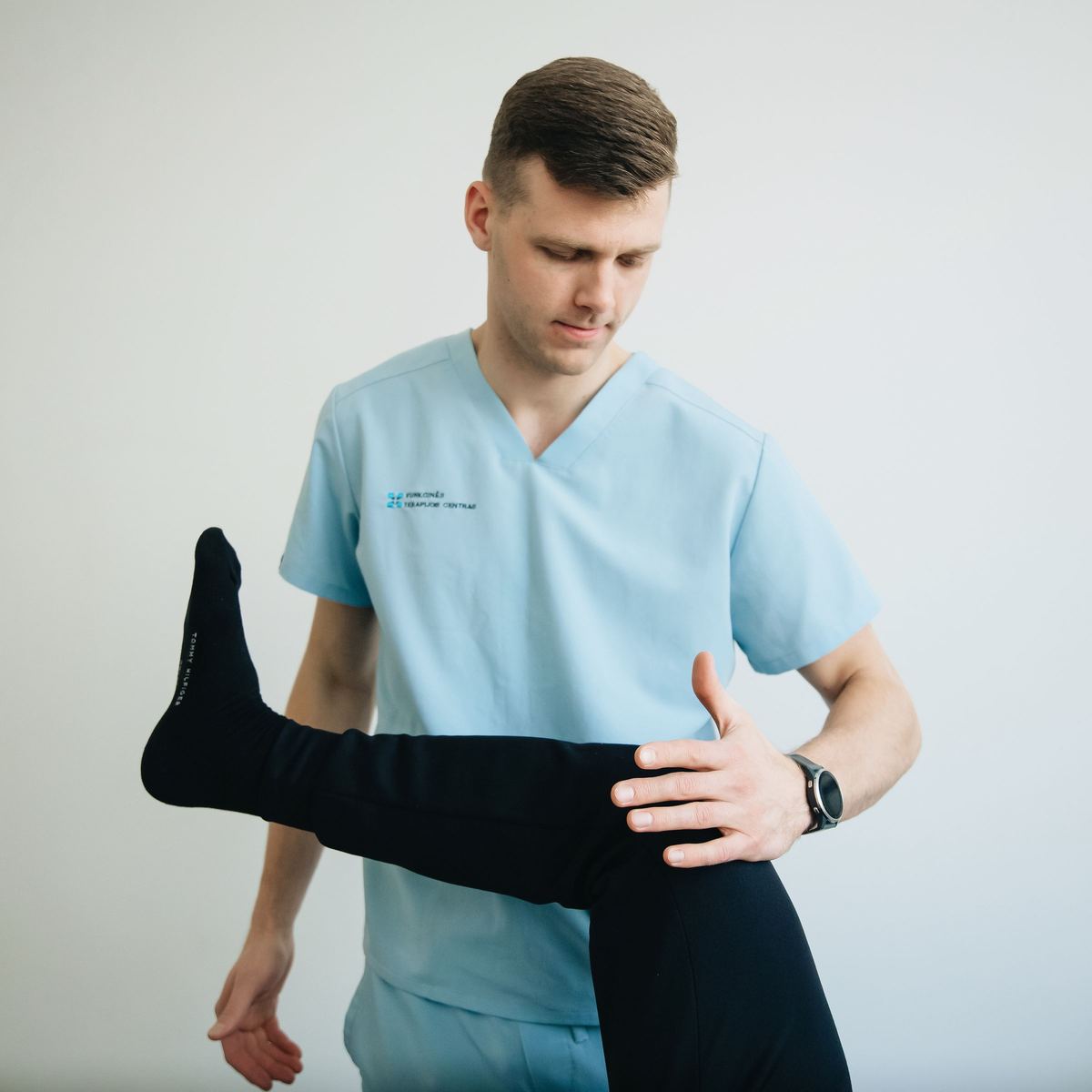 Sports medicine clinician assessing a patient's leg mobility