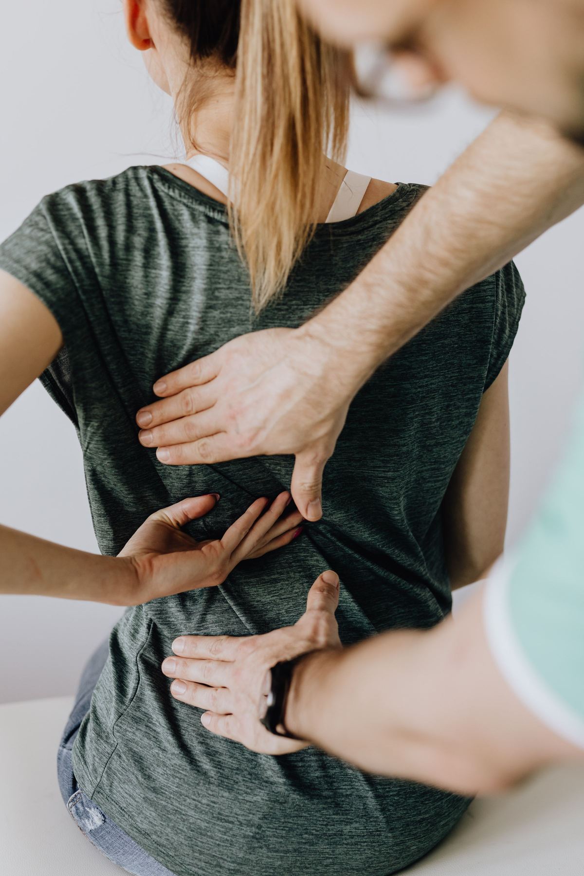 Clinician examining a patient's lower back