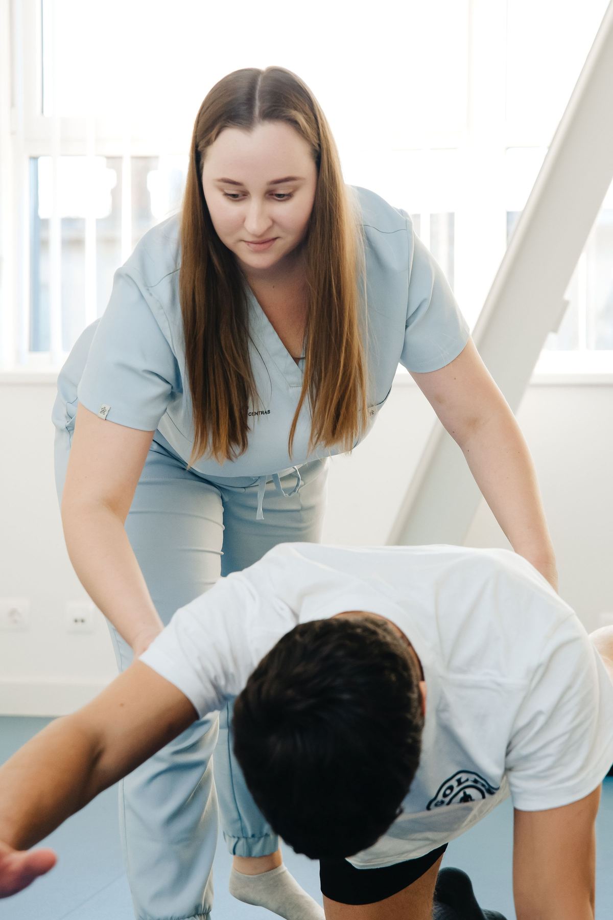 Physical therapist guiding a patient through a rehabilitation exercise